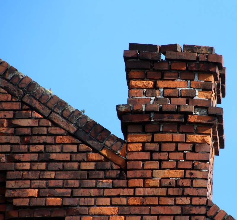 Damaged chimney on an Dover home showing cracks and missing mortar